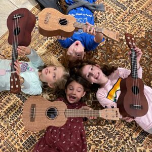 Four young music students with ukuleles.