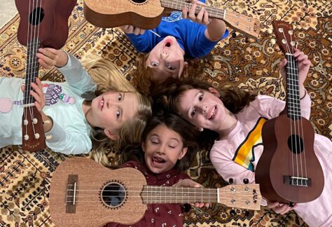 Four young music students with ukuleles.