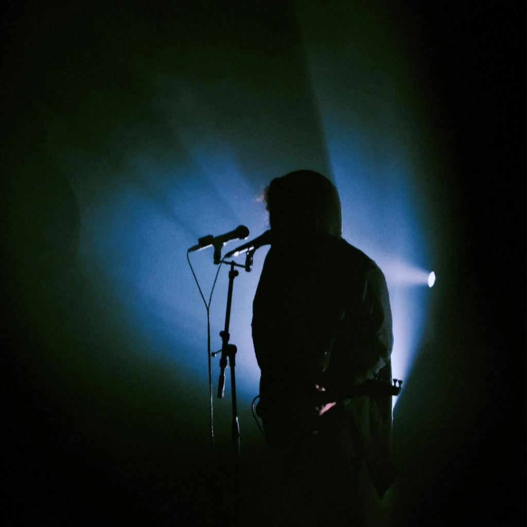 Image of a singer in silhouette.
